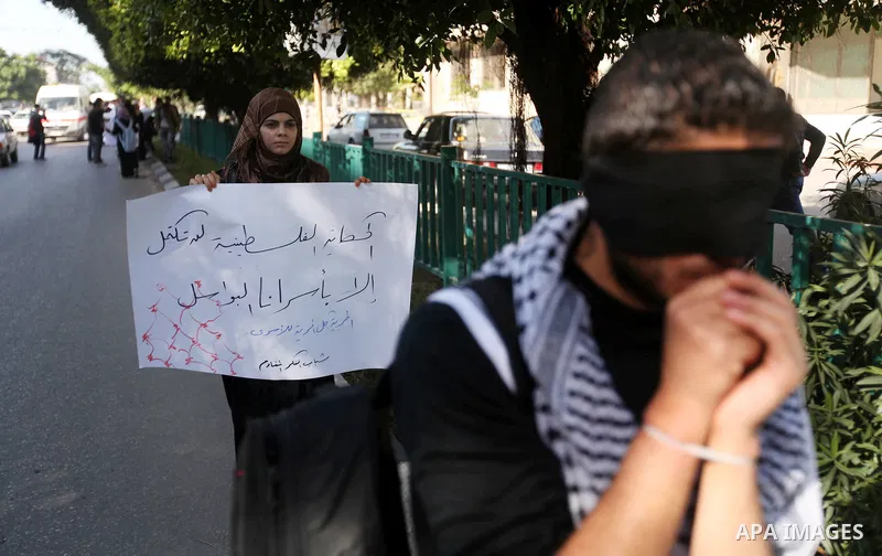 Palestinians youth hold a poster to show his support for Palestinian prisoners currently being held in Israeli jails, some of whom are on hunger strike, in Gaza city, 23, 2012. Photo by Majdi Fathi