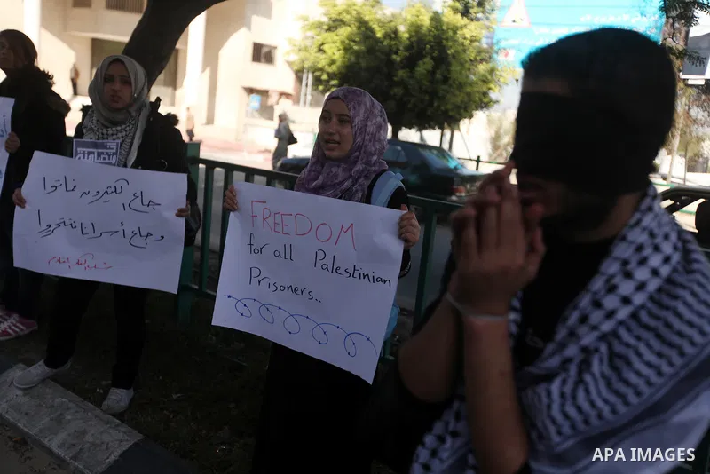 Palestinians youth hold a poster to show his support for Palestinian prisoners currently being held in Israeli jails, some of whom are on hunger strike, in Gaza city, 23, 2012. Photo by Majdi Fathi