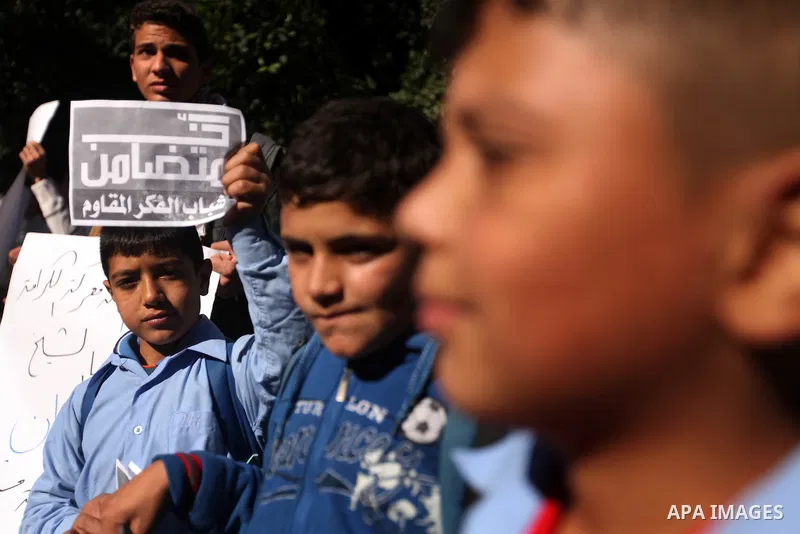 Palestinians youth hold a poster to show his support for Palestinian prisoners currently being held in Israeli jails, some of whom are on hunger strike, in Gaza city, 23, 2012. Photo by Majdi Fathi