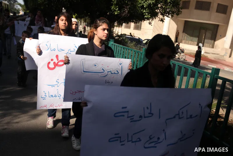 Palestinians youth hold a poster to show his support for Palestinian prisoners currently being held in Israeli jails, some of whom are on hunger strike, in Gaza city, 23, 2012. Photo by Majdi Fathi