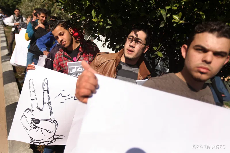 Palestinians youth hold a poster to show his support for Palestinian prisoners currently being held in Israeli jails, some of whom are on hunger strike, in Gaza city, 23, 2012. Photo by Majdi Fathi