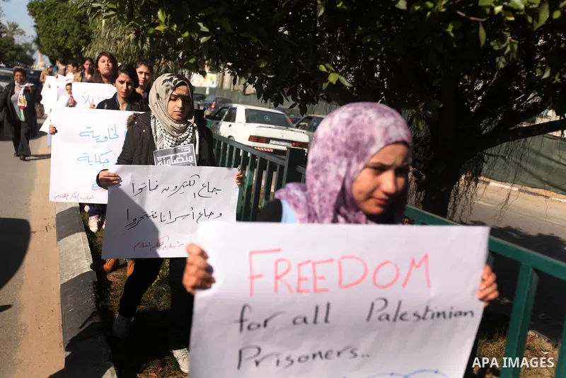 Palestinians youth hold a poster to show his support for Palestinian prisoners currently being held in Israeli jails, some of whom are on hunger strike, in Gaza city, 23, 2012. Photo by Majdi Fathi