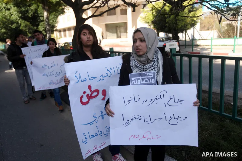 Palestinians youth hold a poster to show his support for Palestinian prisoners currently being held in Israeli jails, some of whom are on hunger strike, in Gaza city, 23, 2012. Photo by Majdi Fathi