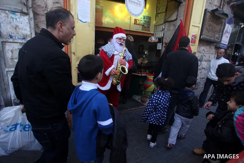 Palestinian Man dressed as Santa Claus walks in the West Bank city of Ramallah on 23 December 2012 .Christmas is celebrated Christians across the globe on December 25 every year. Photo by Issam Rimawi