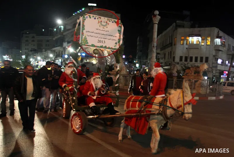 A Palestinian dressed as Santa Claus rides a cart pulled by a donkey in the West Bank city of Ramallah ahead of Christmas on December 23, 2012.Christians across the Israeli occupied Palestinian West Bank are preparing fo...