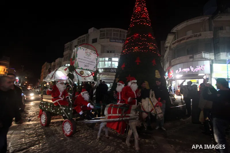 A Palestinian dressed as Santa Claus rides a cart pulled by a donkey in the West Bank city of Ramallah ahead of Christmas on December 23, 2012.Christians across the Israeli occupied Palestinian West Bank are preparing fo...
