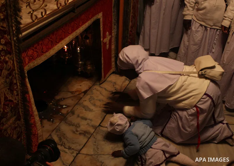 Pilgrims are seen near the 'Grotto,' where Christians believe the Virgin Mary gave birth to Jesus Christ, in the Church of the Nativity, in the West Bank town of Bethlehem on Christmas Day, 24 December 2012. Photo by Iss...