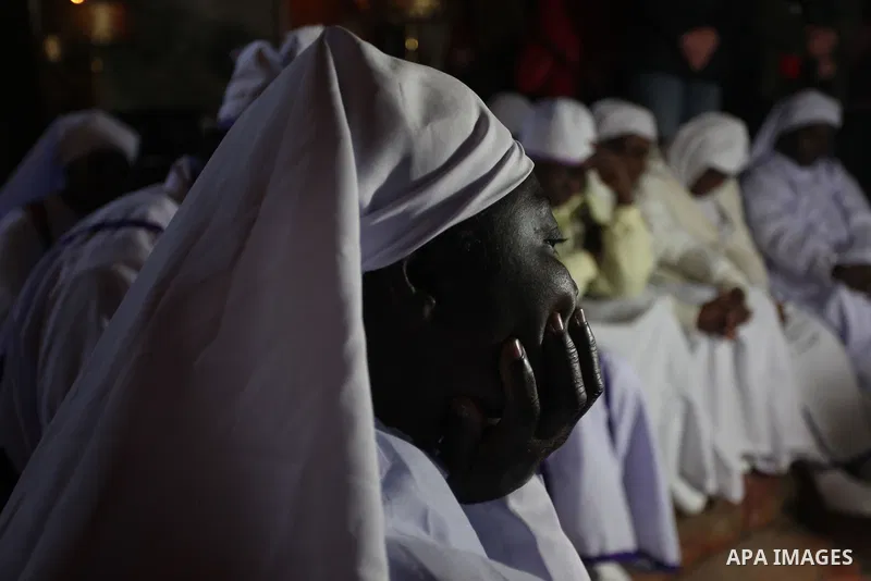 Nigerian pilgrims sit inside the 'Grotto,' where Christians believe the Virgin Mary gave birth to Jesus Christ, in the Church of the Nativity, in the West Bank town of Bethlehem on Christmas Day, 24 December 2012. Photo...