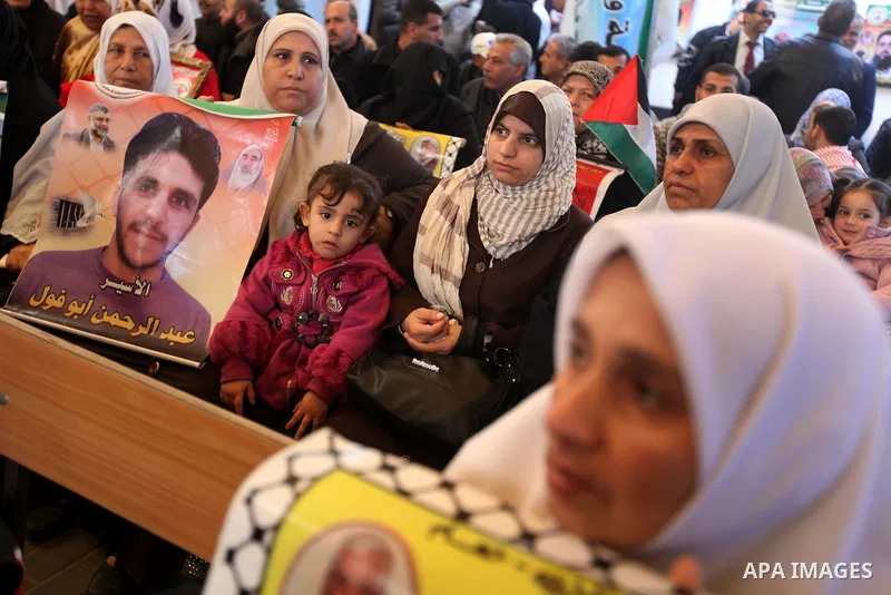Palestinians hold pictures of prisoners held in the Israeli jails during a rally in Gaza city on December 24, 2012. in solidarity with hunger-striking detainees held by Israel to demand their release from detention witho...