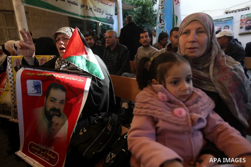 Palestinians hold pictures of prisoners held in the Israeli jails during a rally in Gaza city on December 24, 2012. in solidarity with hunger-striking detainees held by Israel to demand their release from detention witho...