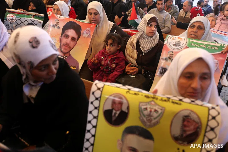 Palestinians hold pictures of prisoners held in the Israeli jails during a rally in Gaza city on December 24, 2012. in solidarity with hunger-striking detainees held by Israel to demand their release from detention witho...