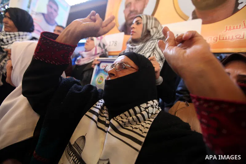 Palestinians hold pictures of prisoners held in the Israeli jails during a rally in Gaza city on December 24, 2012. in solidarity with hunger-striking detainees held by Israel to demand their release from detention witho...