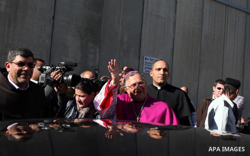 The Latin Patriarch of Jerusalem Fuad Twal, the head of the Roman Catholic Church in the Holy Land, waves to the crowds as he arrives in the West Bank city of Bethlehem after crossing Israel's separation barrier on Decem...