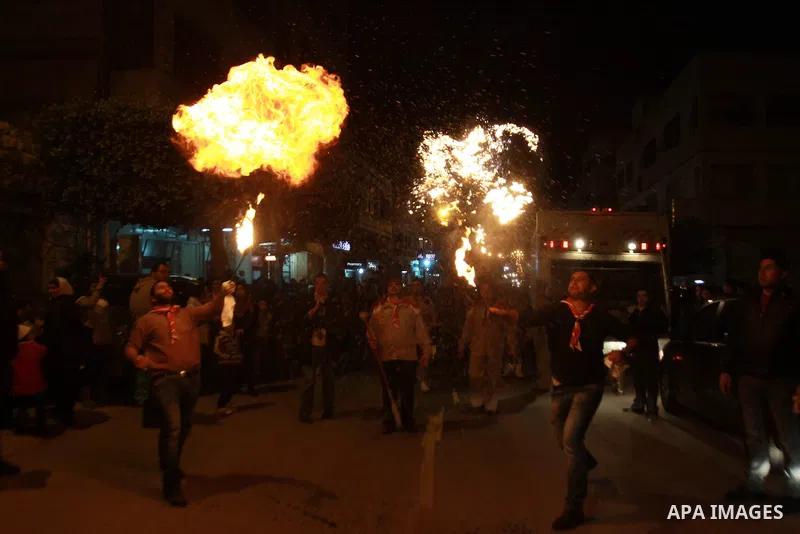 A Palestinian man spews fire from his mouth as he attends the Christmas celebrations in the West Bank city of Nablus on Dec. 24, 2012. Photo by Nedal Eshtayah