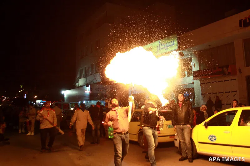 A Palestinian man spews fire from his mouth as he attends the Christmas celebrations in the West Bank city of Nablus on Dec. 24, 2012. Photo by Nedal Eshtayah
