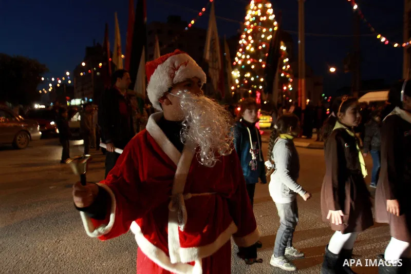Palestinian man dressed as Santa Claus parades as he attends the Christmas celebrations in the West Bank city of Nablus on Dec. 24, 2012. Photo by Nedal Eshtayah