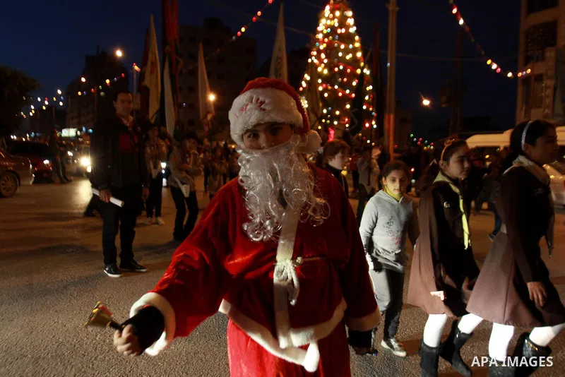 Palestinian man dressed as Santa Claus parades as he attends the Christmas celebrations in the West Bank city of Nablus on Dec. 24, 2012. Photo by Nedal Eshtayah