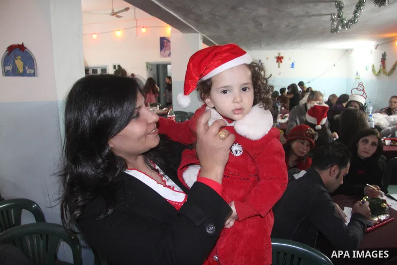 A Palestinian Christian with her son at a church of Deir Latin, during Christmas celebrations in in Gaza city, on December 24, 2012. Photo by Ezz al-Zanoon