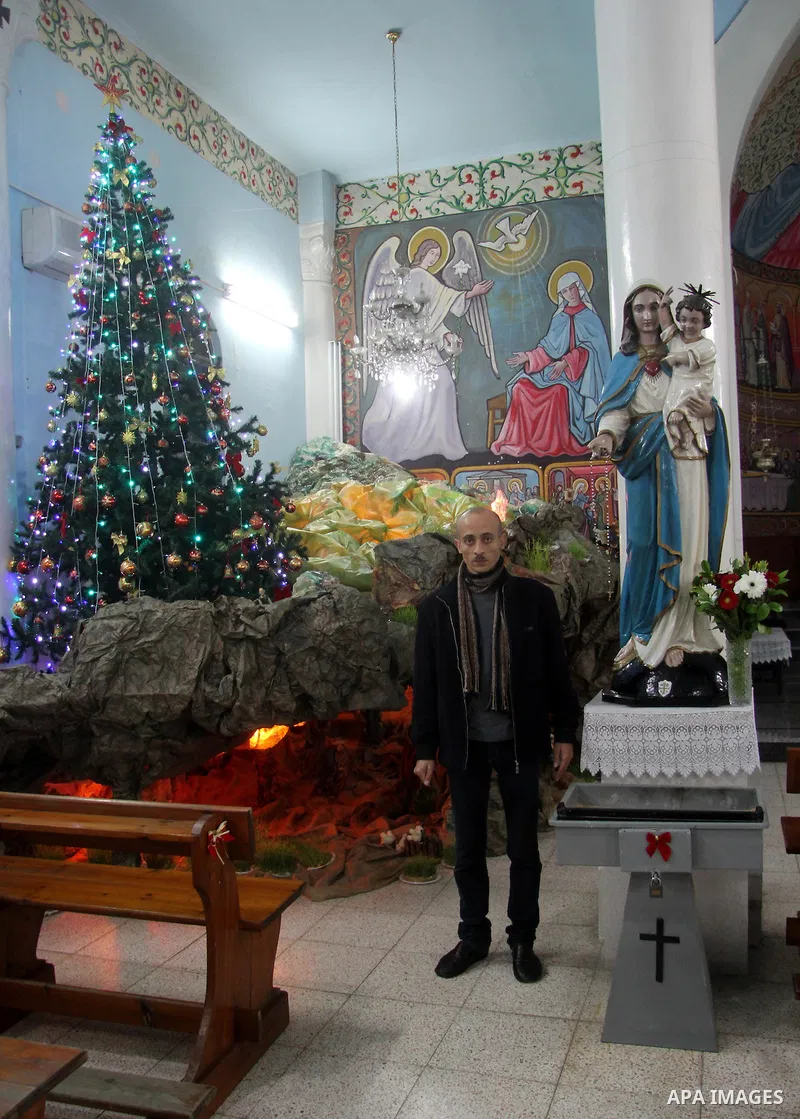 A Palestinian Christian with his son at a church of Deir Latin, during Christmas celebrations in in Gaza city, on December 24, 2012. Photo by Ezz al-Zanoon