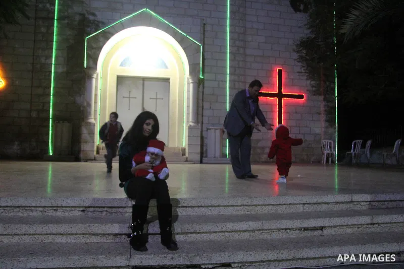 A Palestinian Christian with her son at a church of Deir Latin, during Christmas celebrations in in Gaza city, on December 24, 2012. Photo by Ezz al-Zanoon