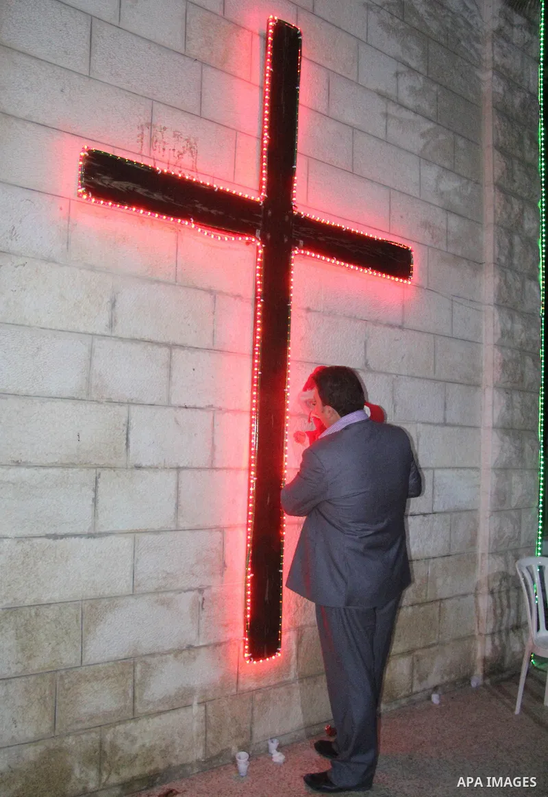 A Palestinian Christian with his son at a church of Deir Latin, during Christmas celebrations in in Gaza city, on December 24, 2012. Photo by Ezz al-Zanoon