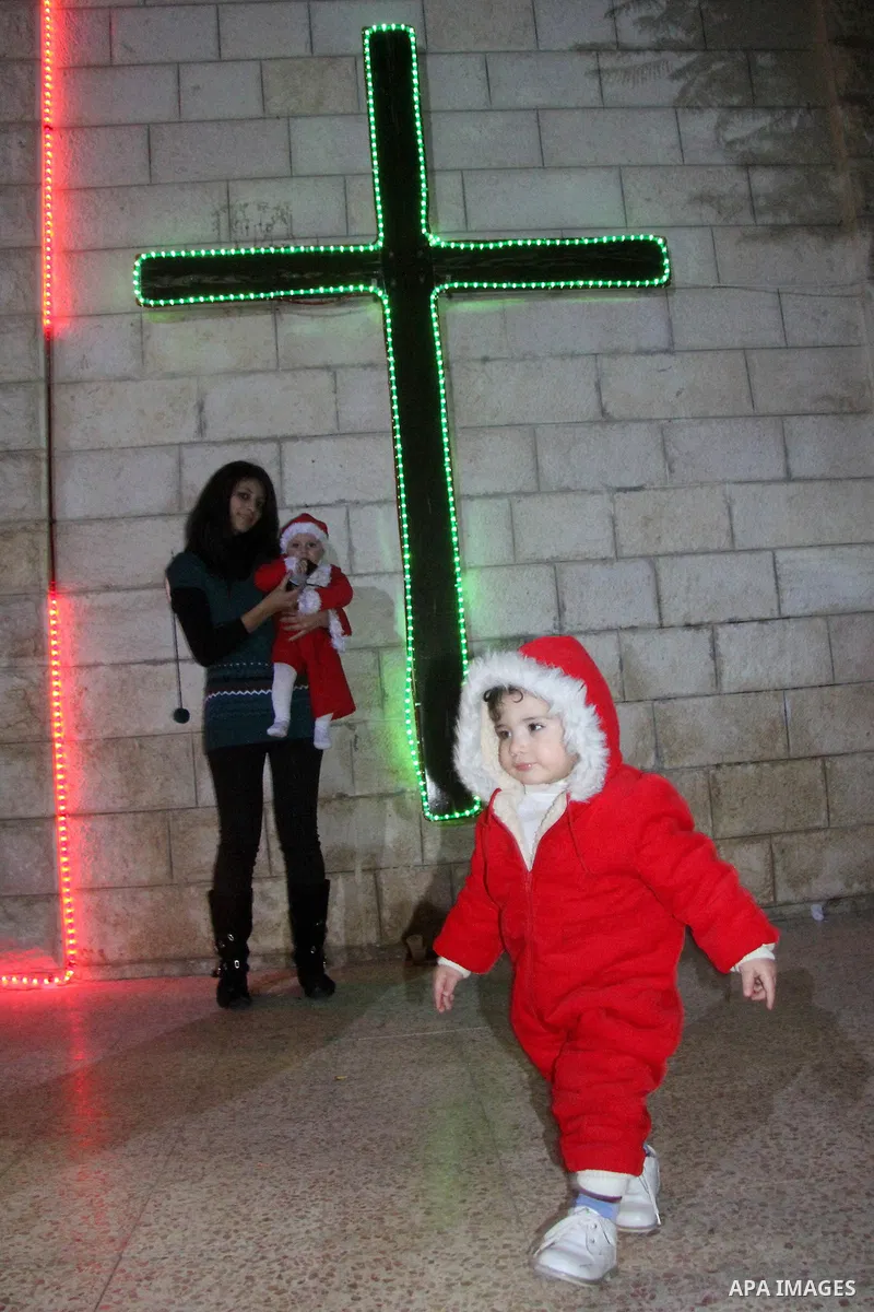 A Palestinian Christian with her son at a church of Deir Latin, during Christmas celebrations in in Gaza city, on December 24, 2012. Photo by Ezz al-Zanoon