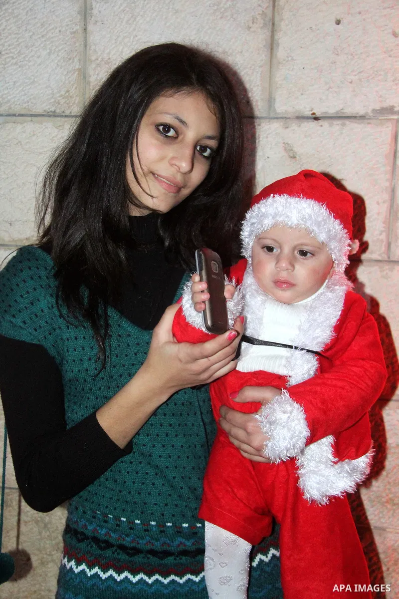 A Palestinian Christian with her son at a church of Deir Latin, during Christmas celebrations in in Gaza city, on December 24, 2012. Photo by Ezz al-Zanoon