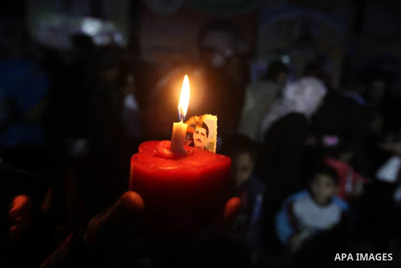 A Palestinian woman holds a candle during a candlelight rally in solidarity with hunger-striking detainees held by Israel in Gaza city to demand their release from detention without trial. December 25, 2012. Photo by Maj...