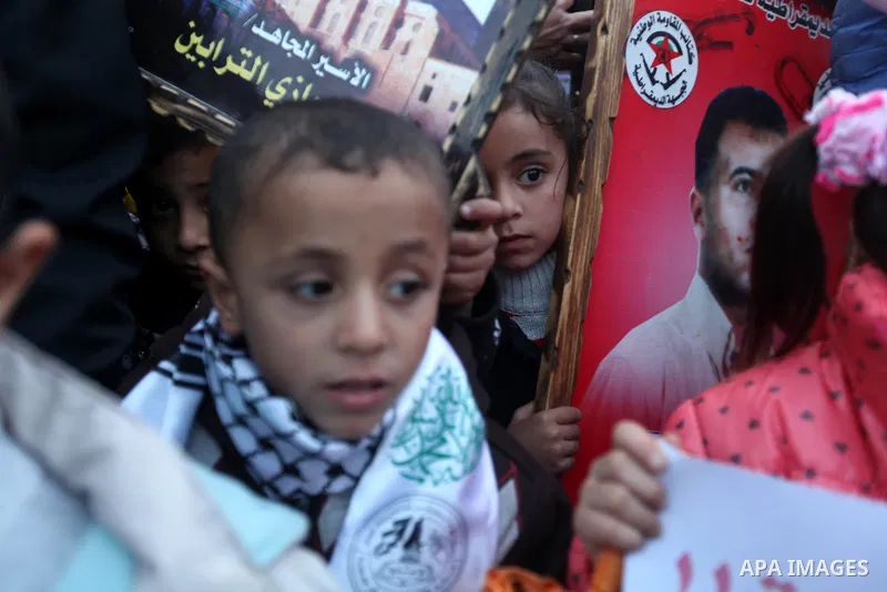 Palestinian children hold placards and candles during a candlelight rally in solidarity with hunger-striking detainees held by Israel in Gaza city to demand their release from detention without trial. December 25, 2012....