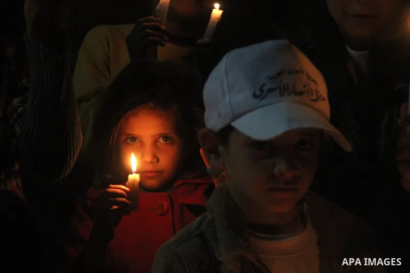 Palestinian children hold candles during a candlelight vigil in front of Red Cross offices, solidarity with hunger-striking detainees held by Israel in Gaza city to demand their release from detention without trial. Dece...