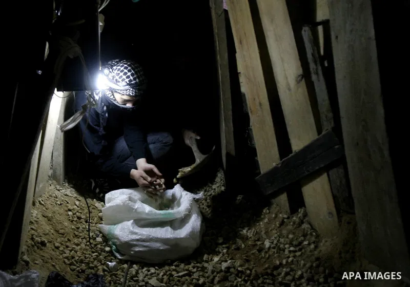 A Palestinian man works inside a tunnel used for smuggling goods, including food, fuel and building materials, along the Gaza-Egypt border in Rafah, in the southern Gaza Strip, on Dec. 27, 2012. The smuggling tunnels und...