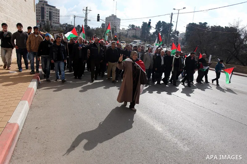 Palestinians hold placards and their national flags during a demonstration in the West Bank city of Ramallah calling for an end in the political division and commitment to the reconciliation agreement between rival Pales...