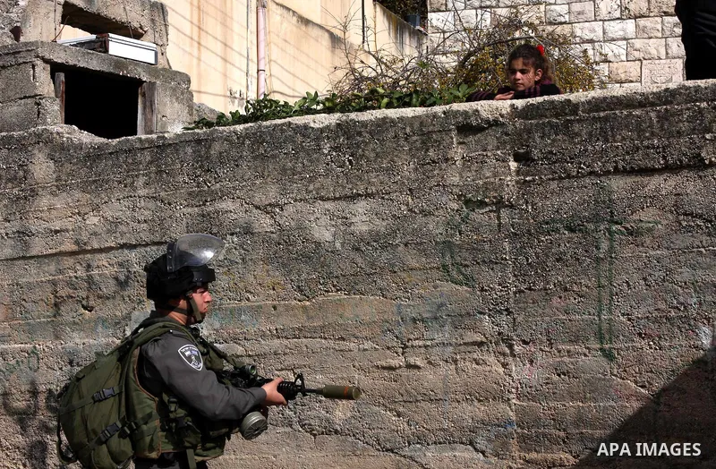 An Israeli soldier stands guard during a search carried out by Israeli soldiers after they raided the village of Urif, near Nablus, West Bank, 27 December 2012. Israeli soldiers raided the village after clashes occurred...