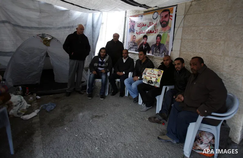 Palestinians gather in front of the Red Cross offices during sit-in outside the Red Cross offices to show solidarity with Palestinian prisoner Samer Issawi who held in an Israeli jail and on hunger strike since August 1...