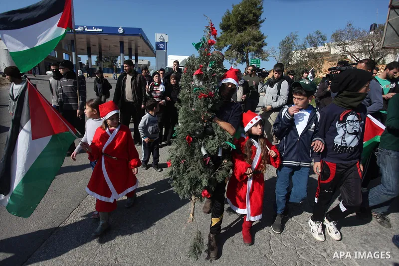 Palestinian protesters wear as Santa Claus during a protest against Jewish settlements, in the West Bank village of Nabi Saleh, near Ramallah December 28, 2012. Photo by Issam Rimawi