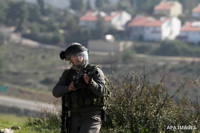 An Israeli security officer shots a tear gas canister at Palestinian stone-throwers during clashes at a protest against Jewish settlements, in the West Bank village of Nabi Saleh, near Ramallah December 28, 2012. Photo b...