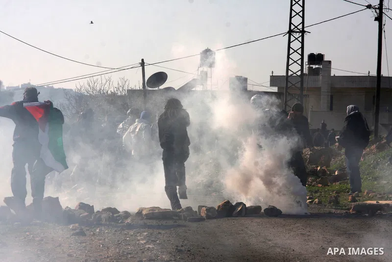 Palestinian demonstrators run cover from tear gas fired by Israeli soldiers during clashes at the weekly protest against the Jewish settlement of Qadomem, near Nablus, West Bank, 28 December 2012. According to Palestinia...