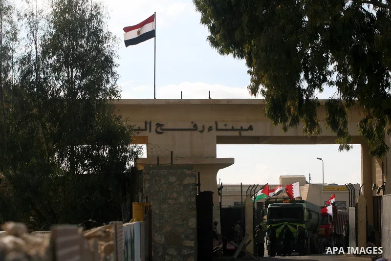Palestinian men stand near trucks of supplying raw materials of Qatari grant projects in Rafah crossing in the southern Gaza Strip. Egypt allowed access supplying raw materials of Qatari grant projects Through the Rafah...