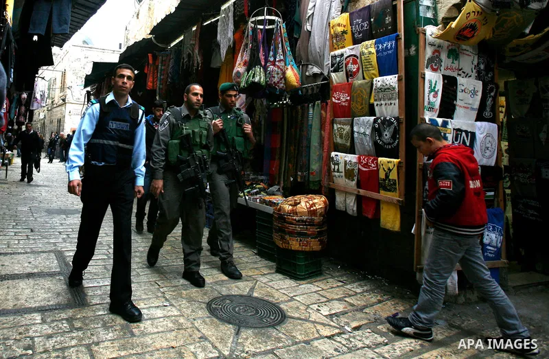 Palestinian man walk past Israeli police at the market in Jerusalem's old city on December 29, 2012. Photo by Mahfouz Abu Turk