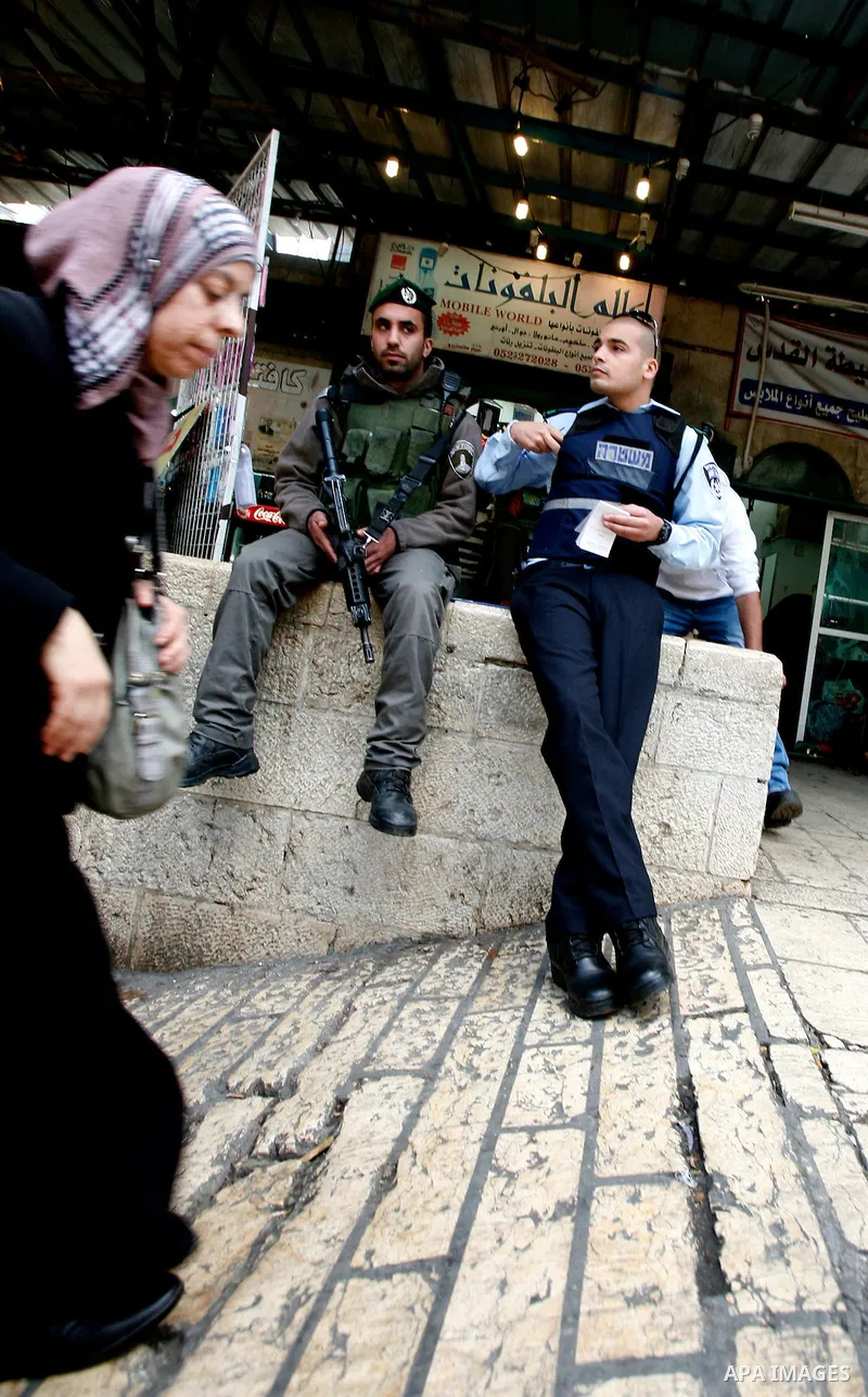 Palestinian woman walk past Israeli police at the market in Jerusalem's old city on December 29, 2012. Photo by Mahfouz Abu Turk