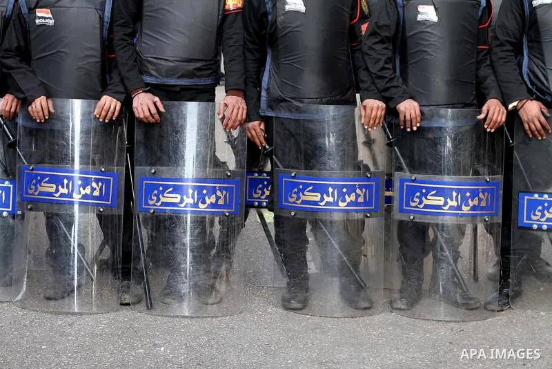 Egyptian riot police stand guard outside the Shura Council, the upper house of parliament where the Constituent Assembly drafted the country's new constitution, as protesters against Egypt's President Mohamed Morsi chant...
