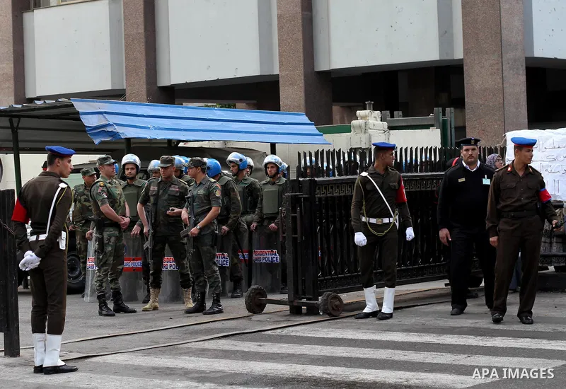 Egyptian riot police stand guard outside the Shura Council, the upper house of parliament where the Constituent Assembly drafted the country's new constitution, as protesters against Egypt's President Mohamed Morsi chant...