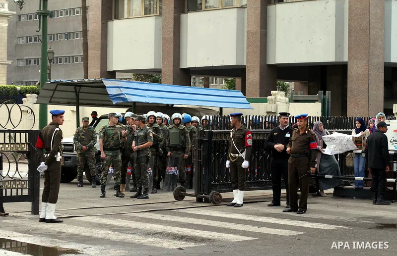Egyptian riot police stand guard outside the Shura Council, the upper house of parliament where the Constituent Assembly drafted the country's new constitution, as protesters against Egypt's President Mohamed Morsi chant...