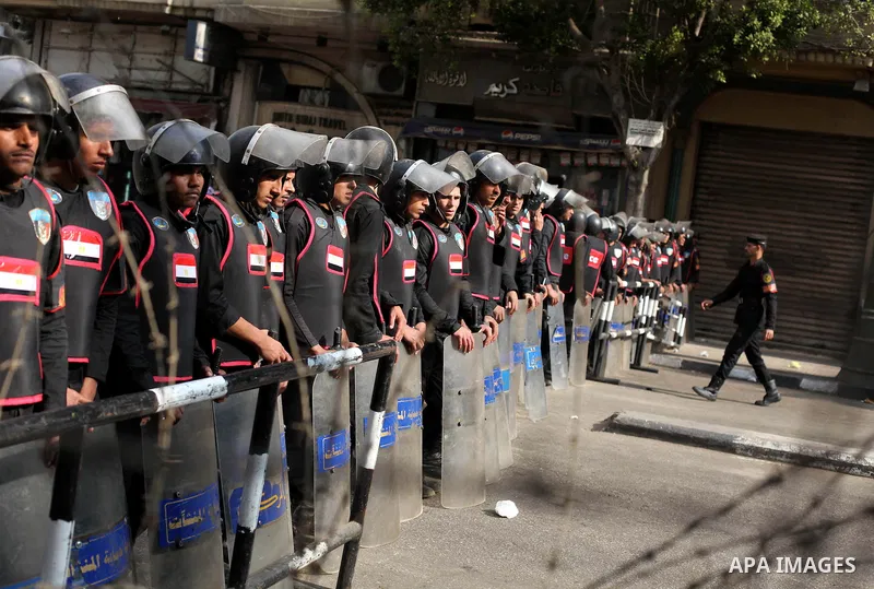 Egyptian riot police stand guard outside the Shura Council, the upper house of parliament where the Constituent Assembly drafted the country's new constitution, as protesters against Egypt's President Mohamed Morsi chant...