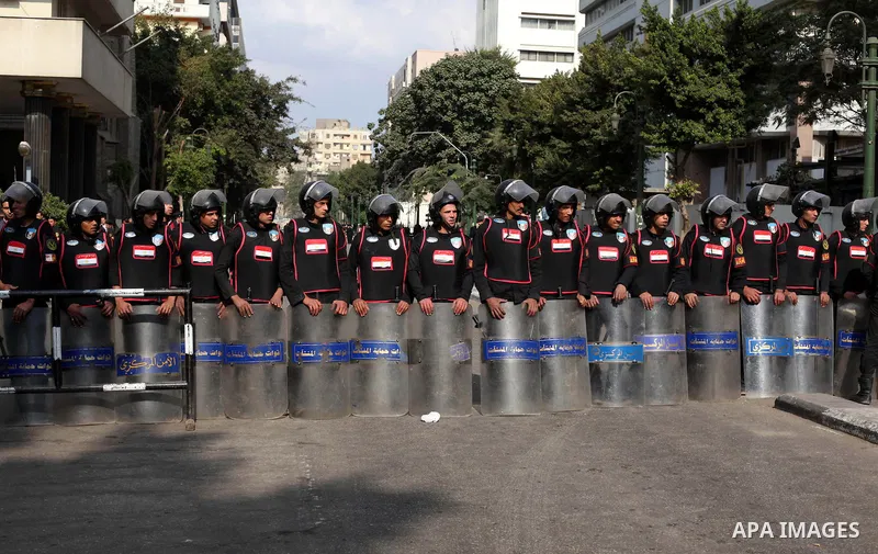 Egyptian riot police stand guard outside the Shura Council, the upper house of parliament where the Constituent Assembly drafted the country's new constitution, as protesters against Egypt's President Mohamed Morsi chant...
