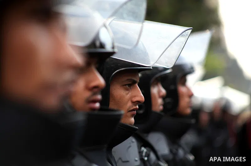 Egyptian riot police stand guard outside the Shura Council, the upper house of parliament where the Constituent Assembly drafted the country's new constitution, as protesters against Egypt's President Mohamed Morsi chant...
