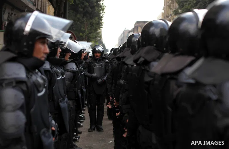 Egyptian riot police stand guard outside the Shura Council, the upper house of parliament where the Constituent Assembly drafted the country's new constitution, as protesters against Egypt's President Mohamed Morsi chant...