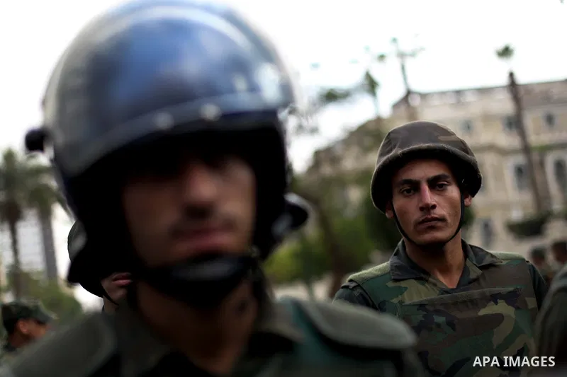 Egyptian riot police stand guard outside the Shura Council, the upper house of parliament where the Constituent Assembly drafted the country's new constitution, as protesters against Egypt's President Mohamed Morsi chant...