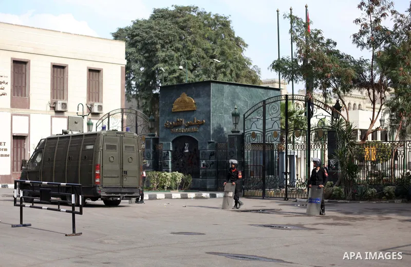 Egyptian riot police stand guard outside the Shura Council, the upper house of parliament where the Constituent Assembly drafted the country's new constitution, as protesters against Egypt's President Mohamed Morsi chant...
