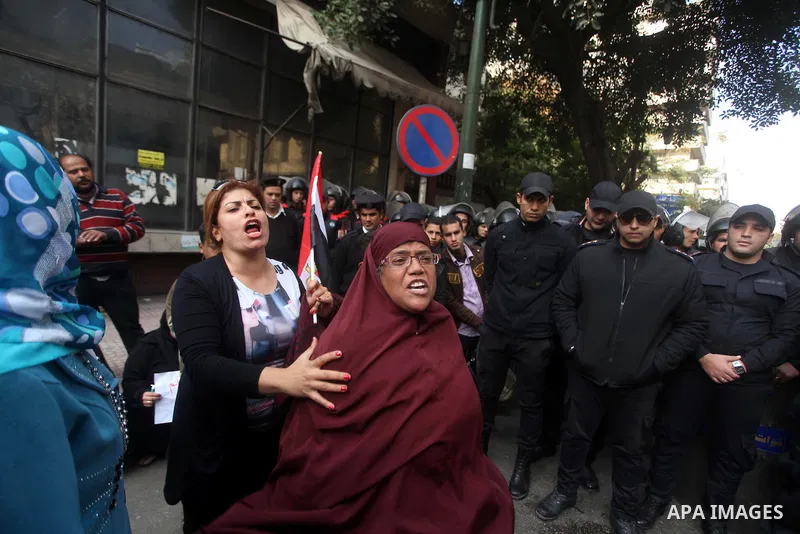 Egyptians women protest against the police officers near the Shura Council, the upper house of parliament where the Constituent Assembly drafted the country's new constitution, as protesters against Egypt's President Moh...